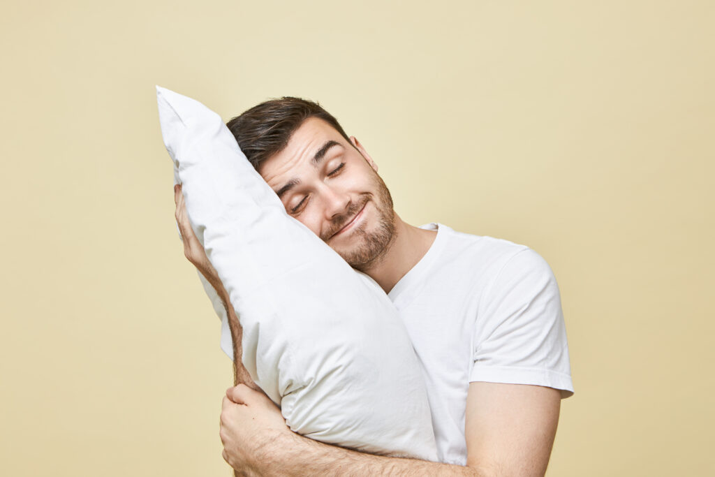 man in white t shirt sleeping on pillow